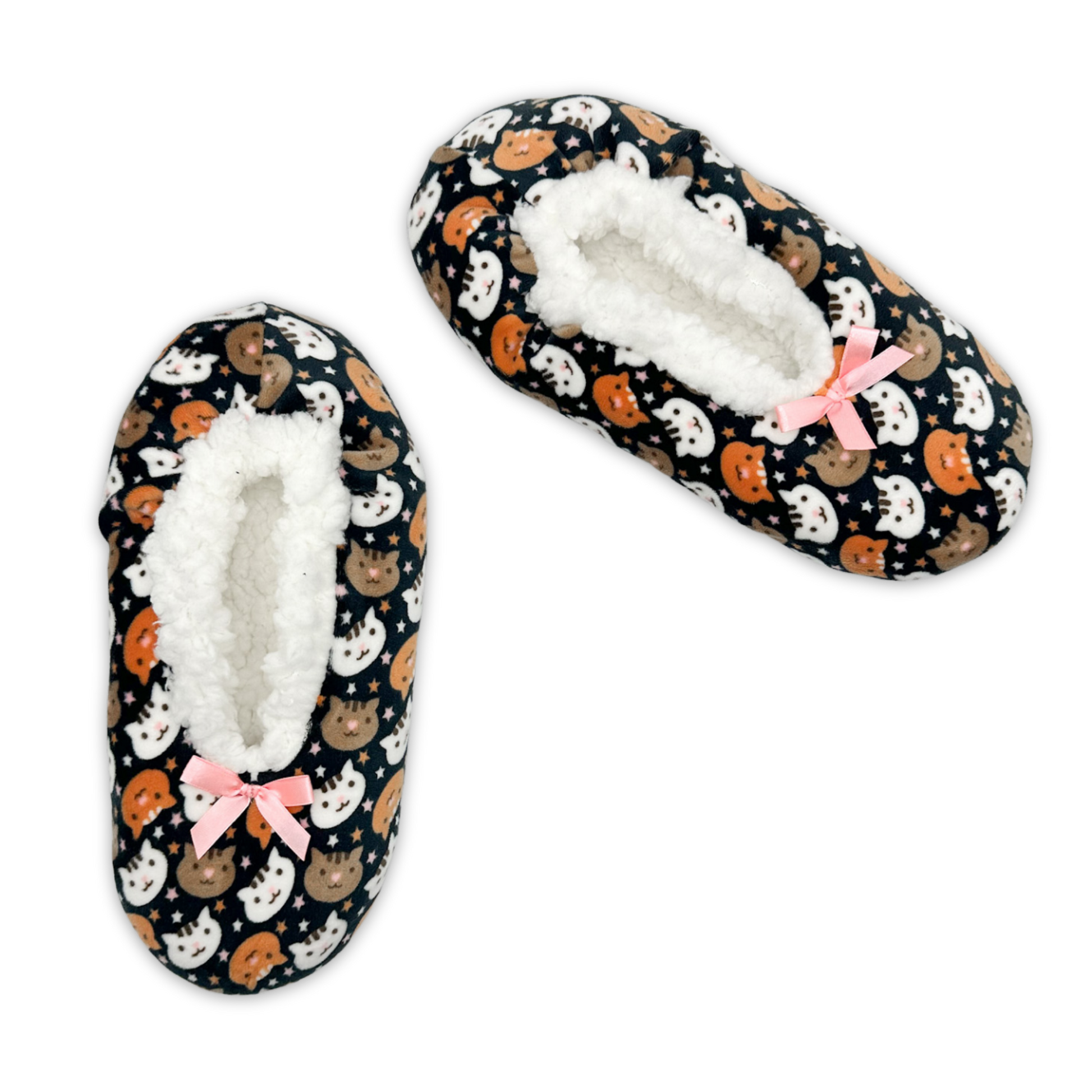 A slipper with a printed pattern comprising of brown and white cat heads on a black background with a pink bow.