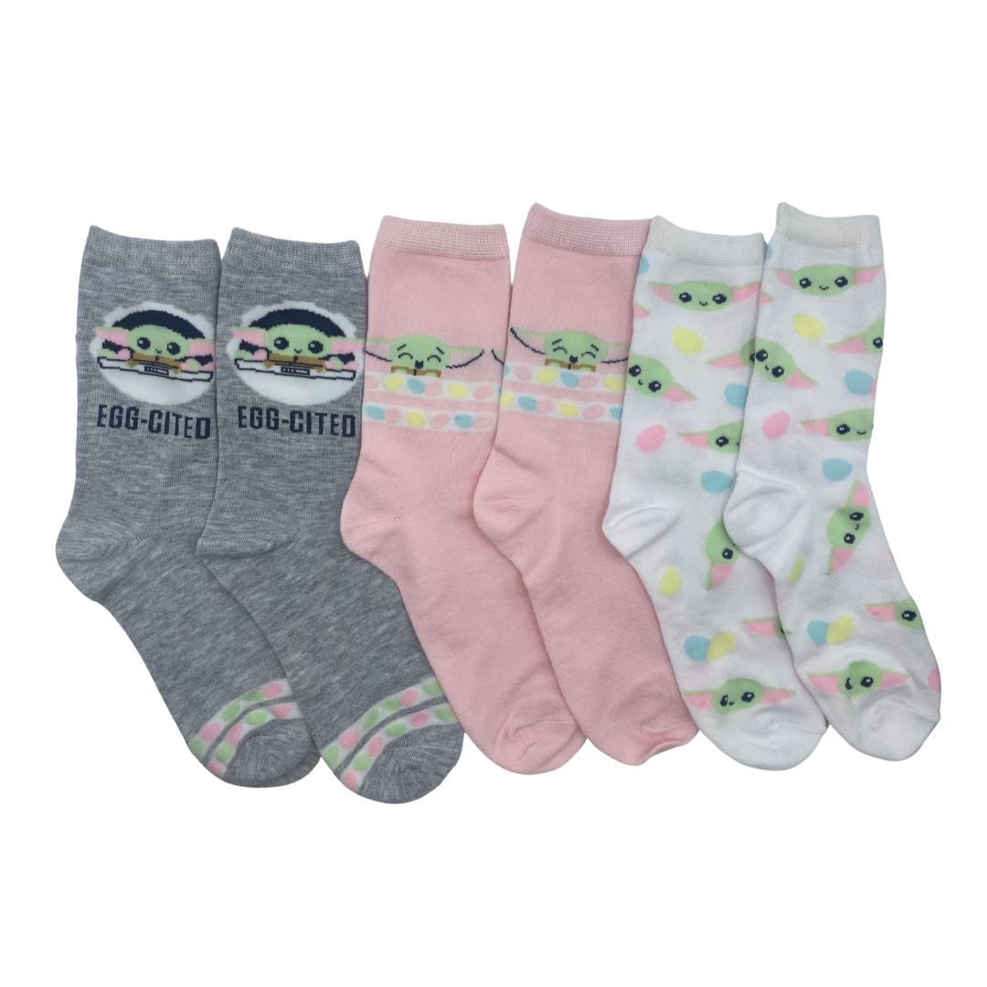 Three pairs of socks.

The first consists of a grey background with a Baby Yoda motif above the ankle with the phrase "egg-cited" below it.

The second consists of a grey background with a Baby Yoda motif above the ankle with two stripes containing colorful circles below it.

The third is a light grey sock with a motif of Baby Yoda's face printed all over.