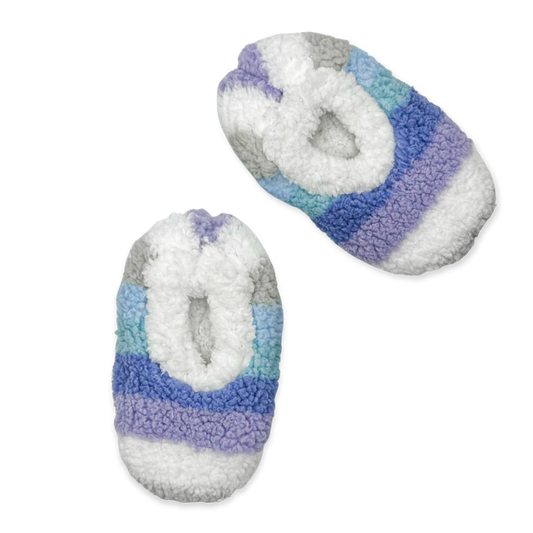The image depicts a pair of galaxy ombre striped slippers. The slippers are made of a soft, fuzzy material and have a closed toe design. They are perfect for keeping your feet warm and cozy on cold days.